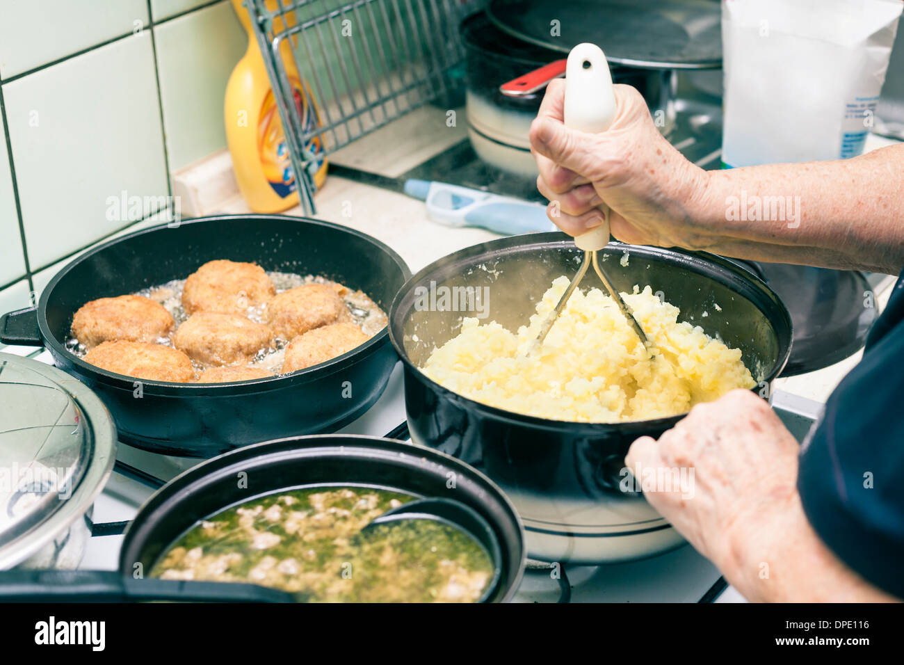 Detail of woman cooking lunch on cooker at home, Czech Republic. Stock Photo