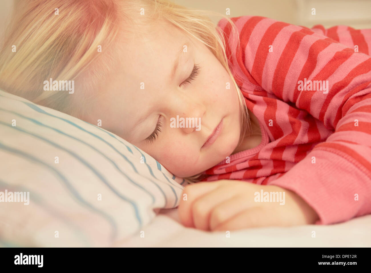 Young girl asleep in bed Stock Photo