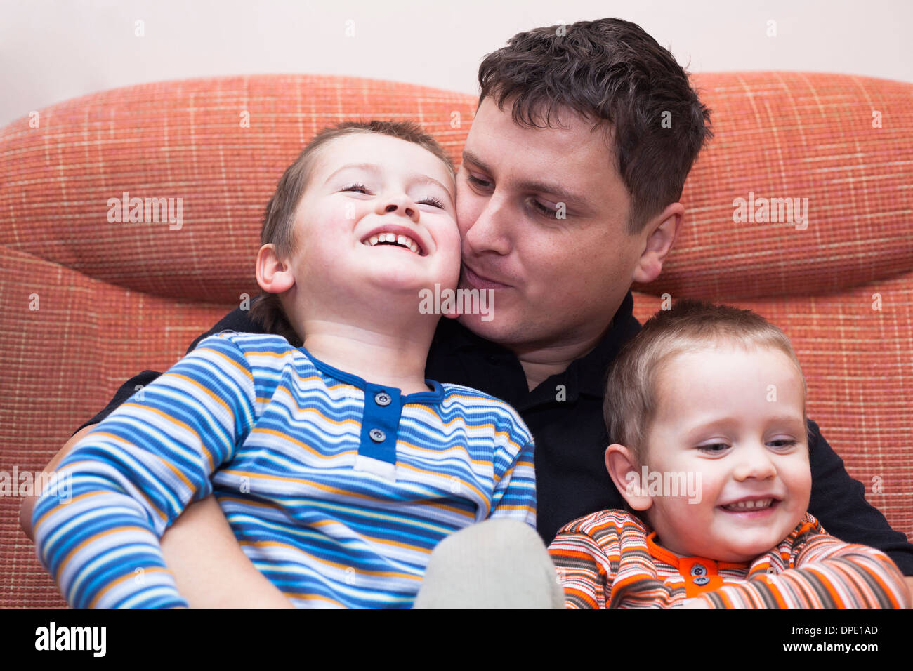 Closeup of happy children boys and daddy having fun on sofa at home Stock Photo