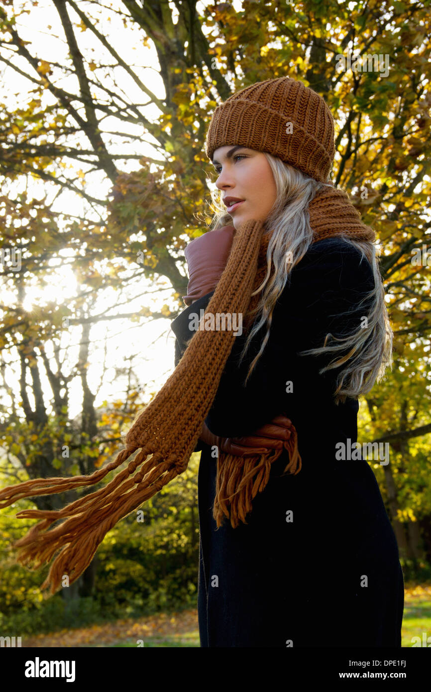 Young woman wrapped up in autumnal park Stock Photo