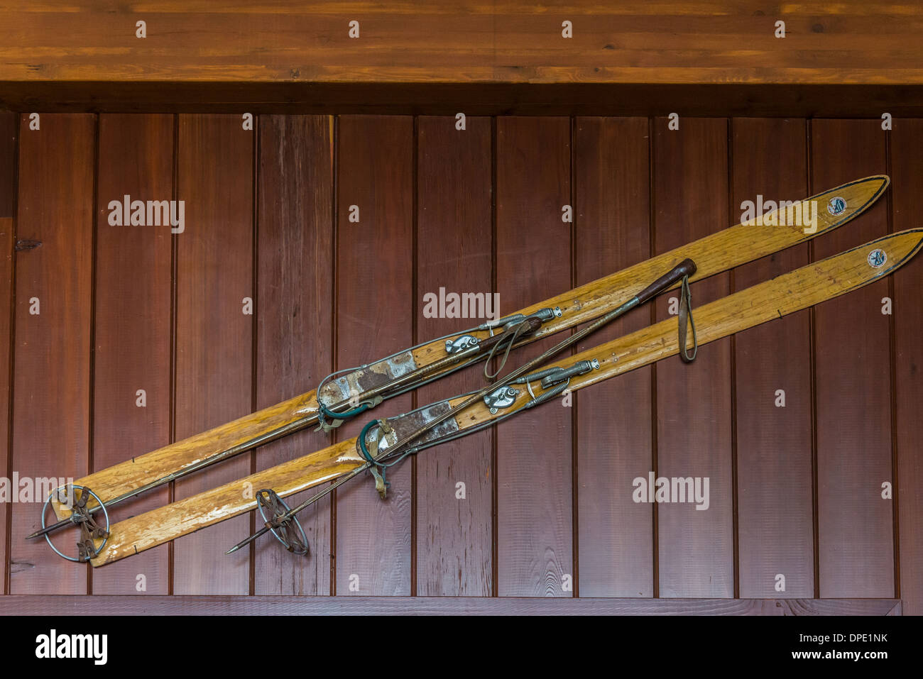 A pair of old style wooden skis hanging on the wall. Stock Photo
