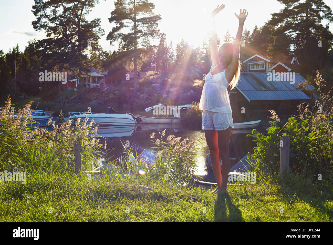 Young woman dancing next to lake, Gavle, Sweden Stock Photo