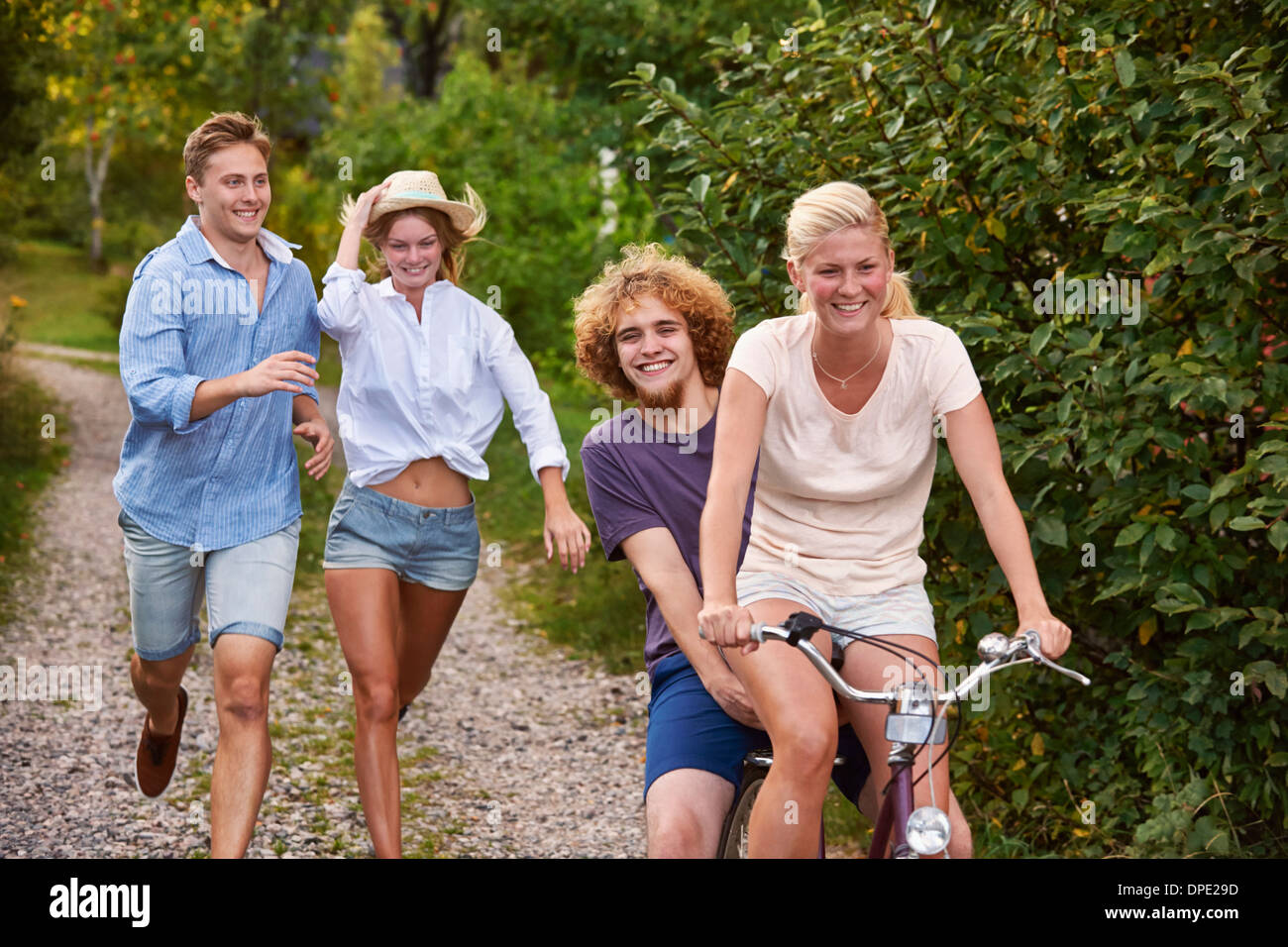 Two young couples chasing each other on bicycle, Gavle, Sweden Stock Photo