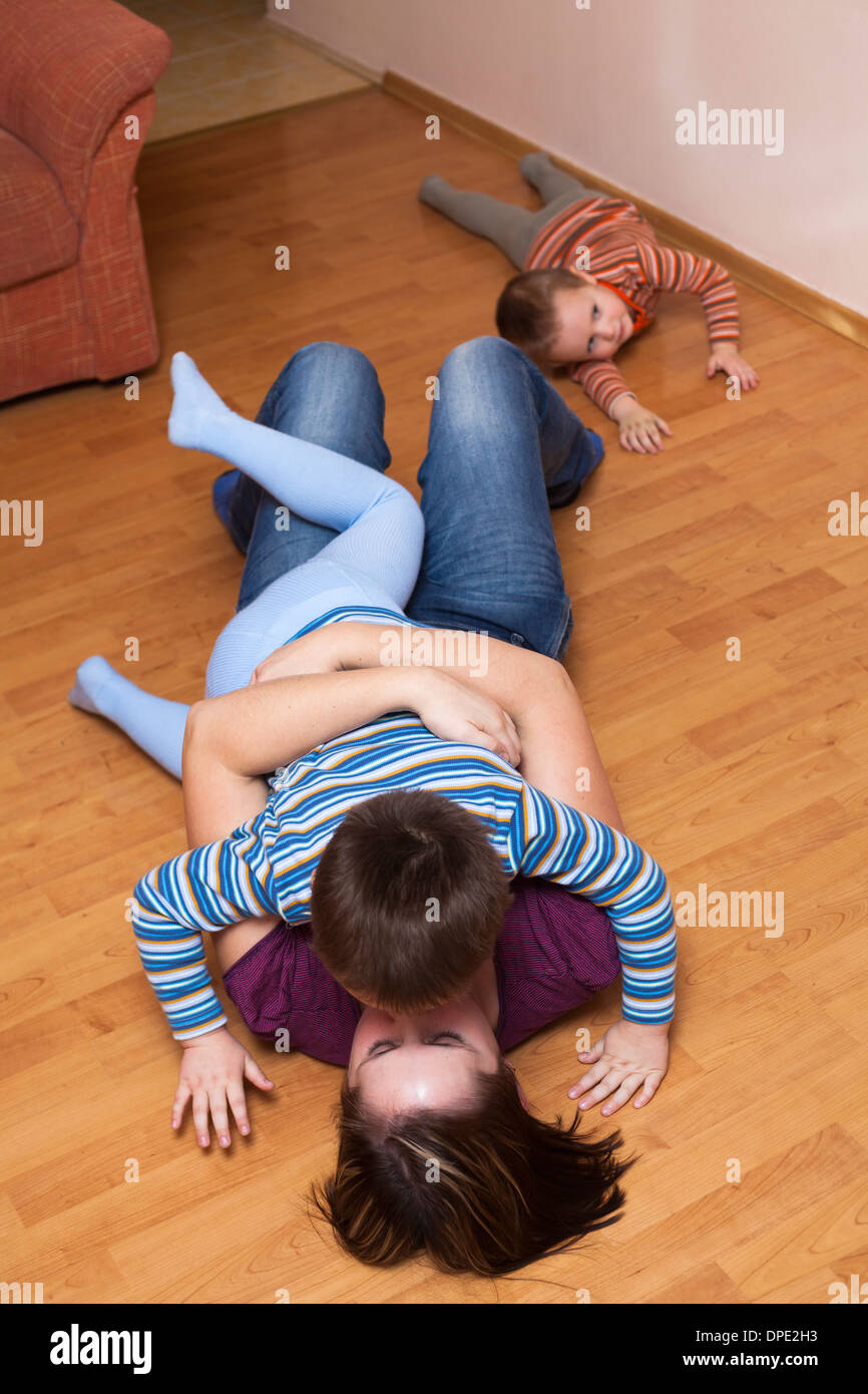Happy mother kissing her son and lying on the floor at home Stock Photo