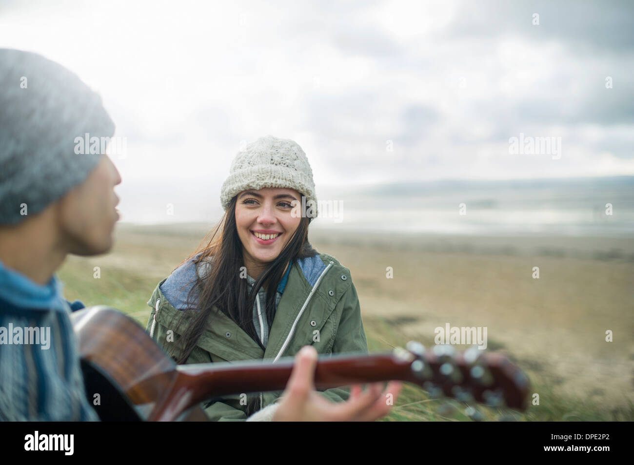 Young man playing guitar, Brean Sands, Somerset, England Stock Photo