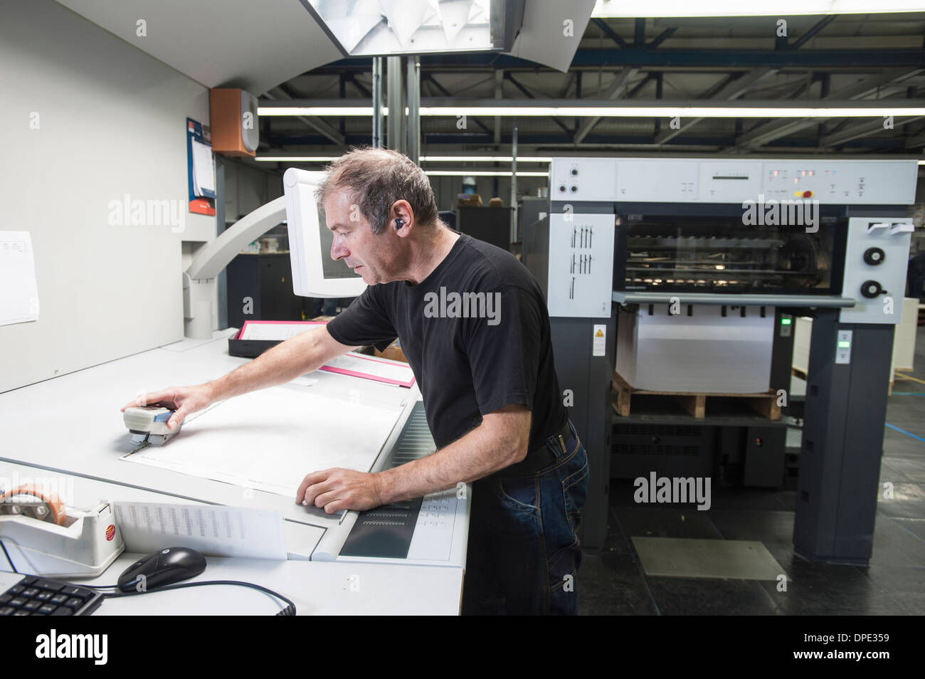 Worker preparing digital printing equipment in print workshop Stock Photo