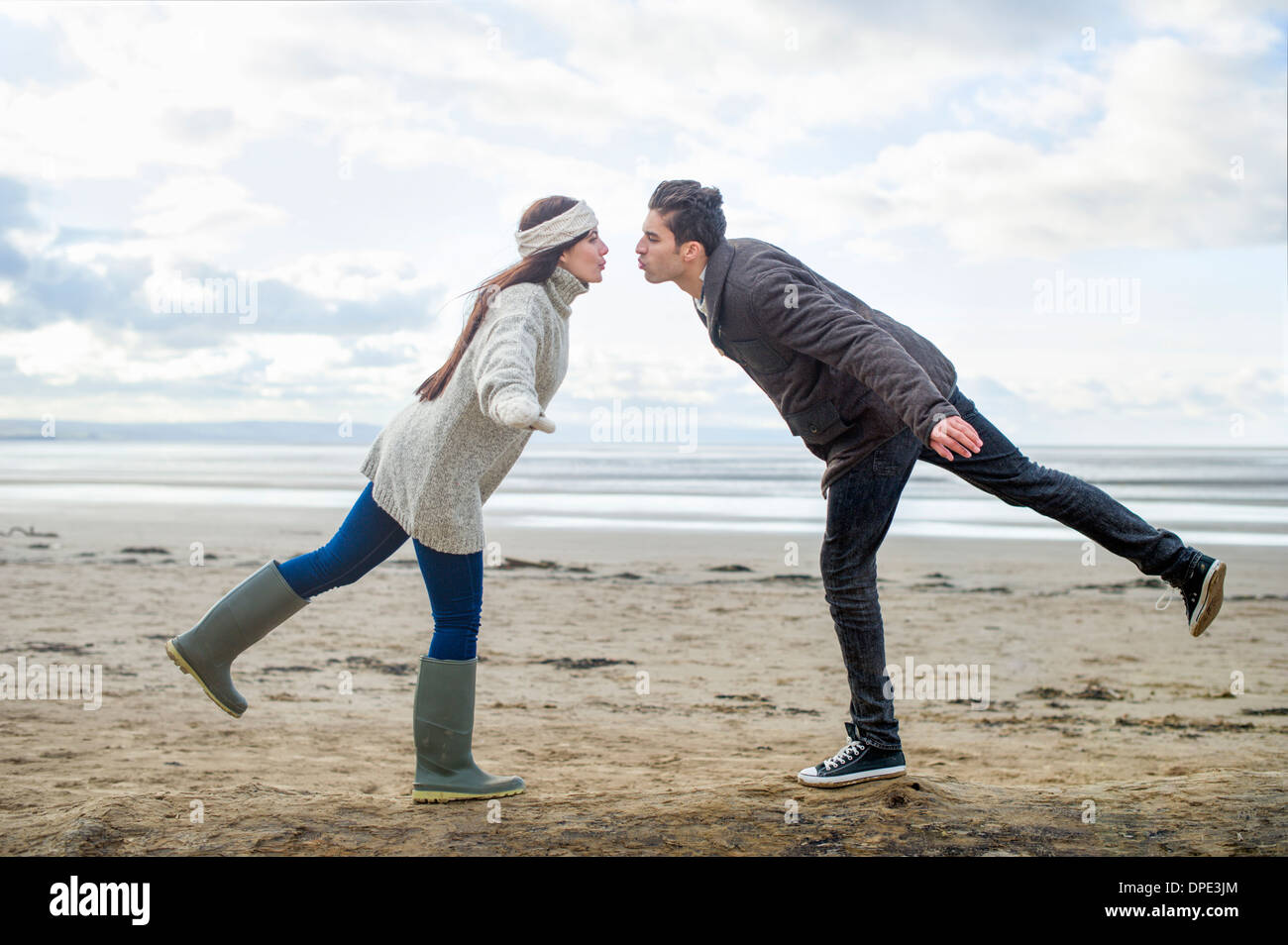 Young couple on one leg, Brean Sands, Somerset, England Stock Photo