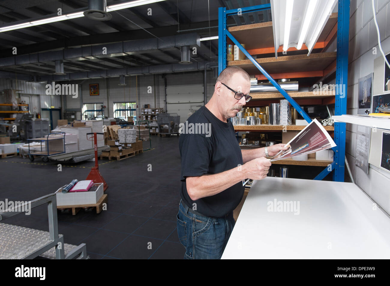 Worker checking quality of print products in printing workshop Stock Photo