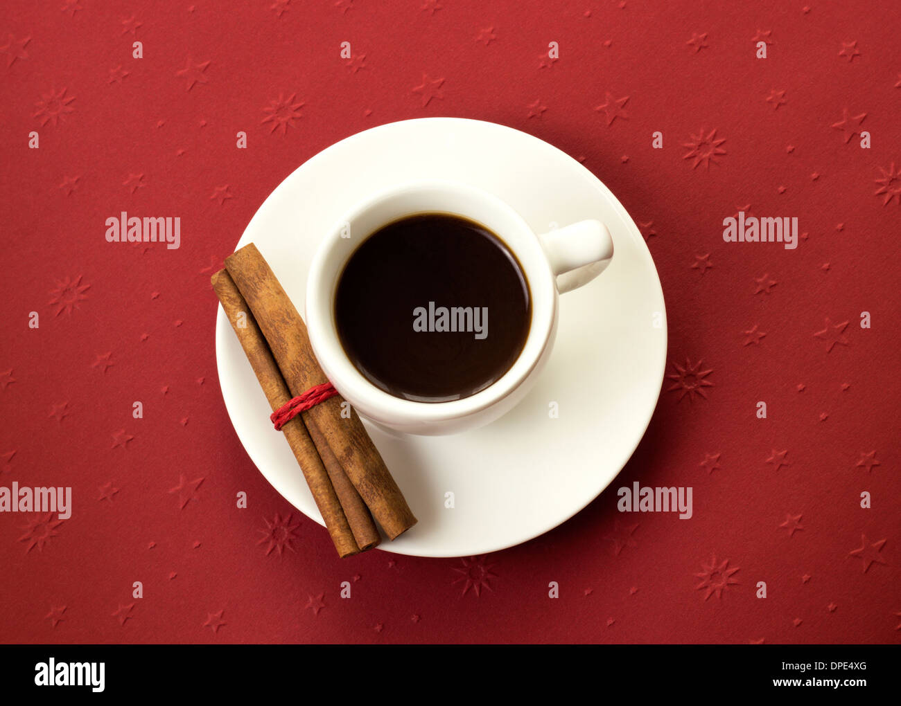 coffee cup with cinnamon sticks on red table Stock Photo