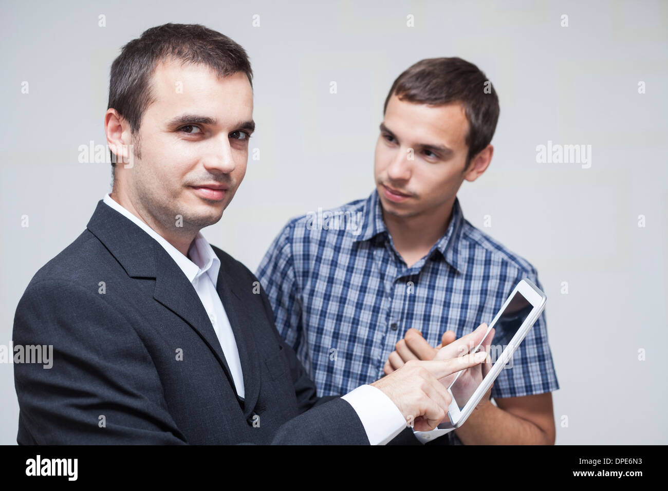 Two businessmen using digital tablet in the office. Stock Photo