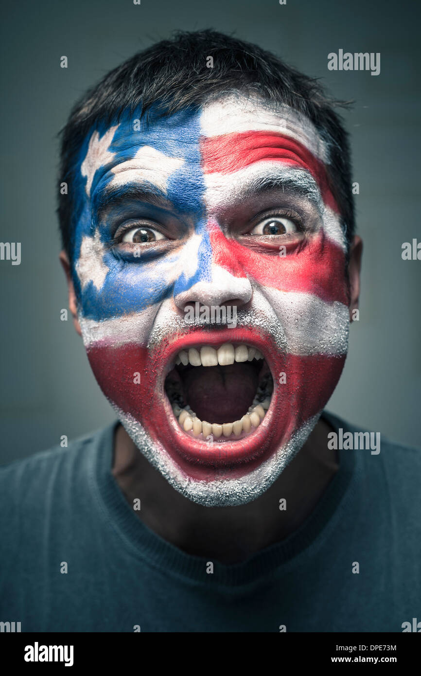 Portrait of angry man with USA flag painted on face. Stock Photo