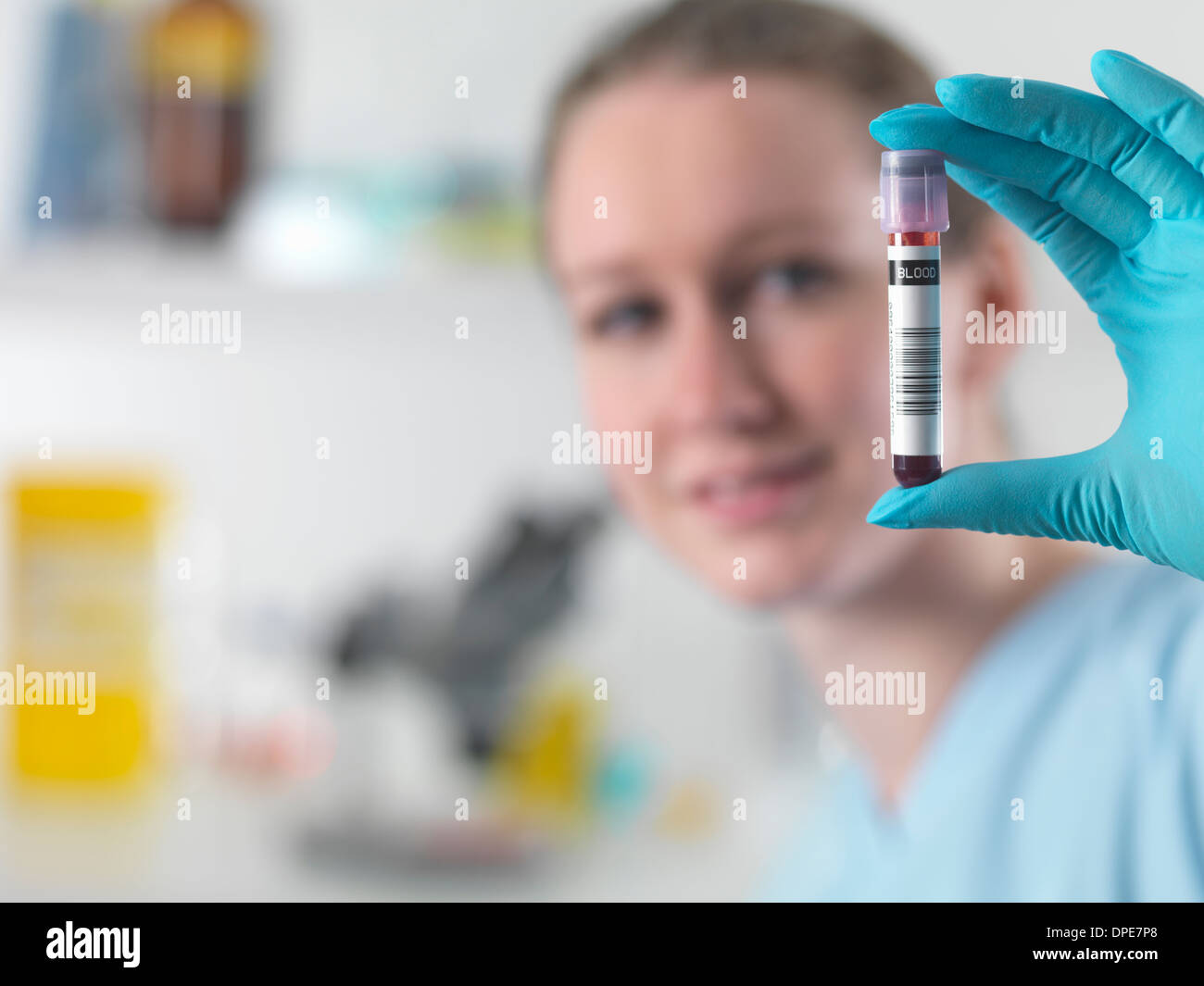 Technician holding bar coded blood sample in clinical laboratory Stock Photo