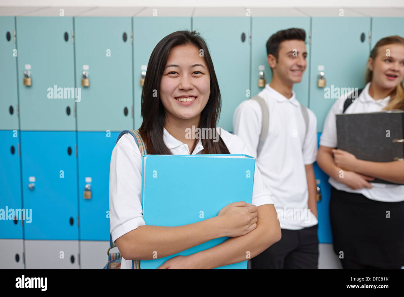 Portrait of teenage schoolgirl next to lockers Stock Photo