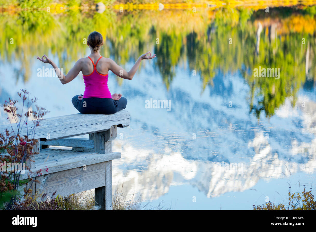 Woman meditating by lake, Bellingham, Washington, USA Stock Photo