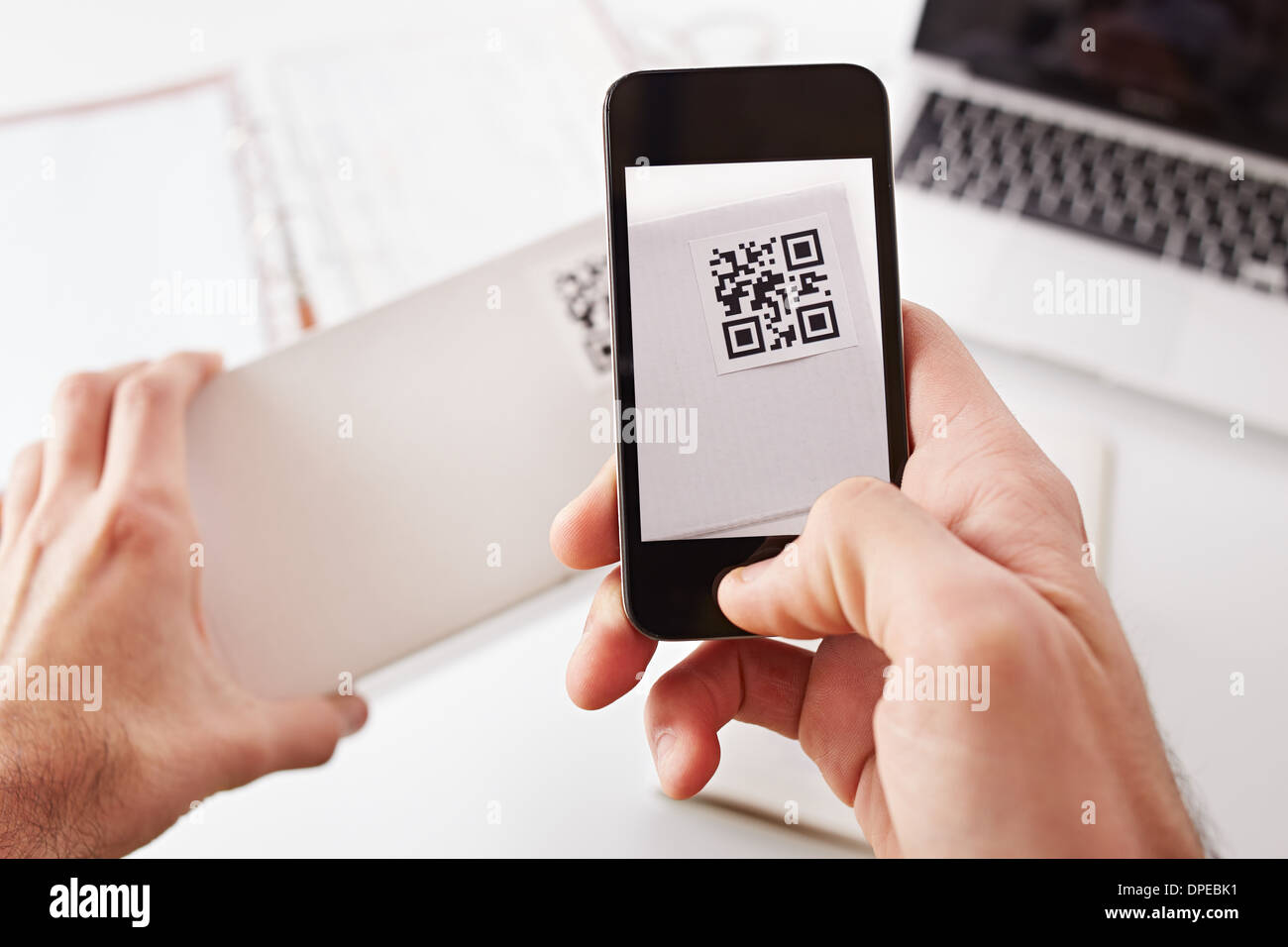 Smartphone taking photo of QR code on a white box Stock Photo