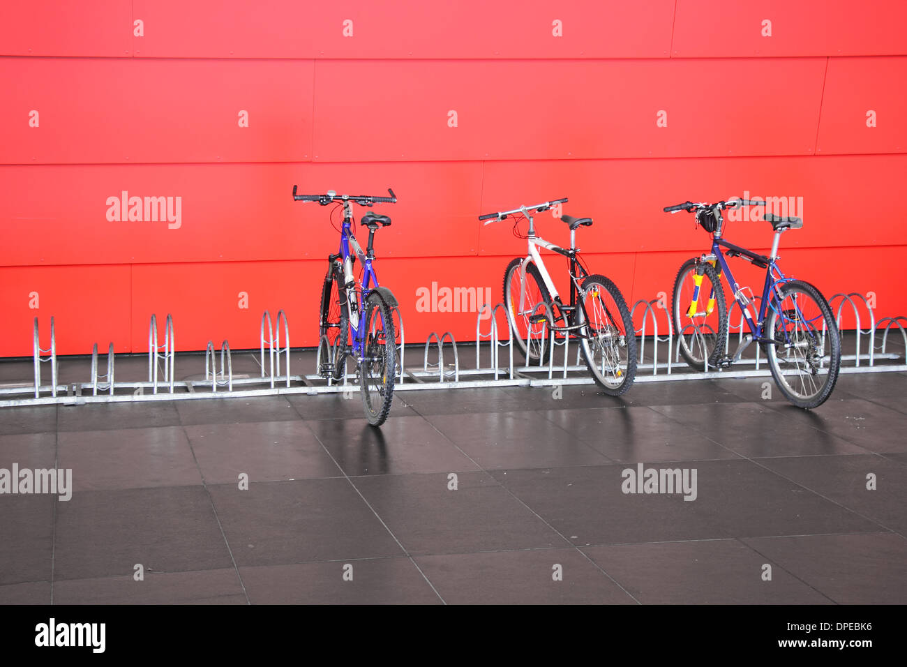 Metal spiral holder for bikes set up in front of retail store Stock
