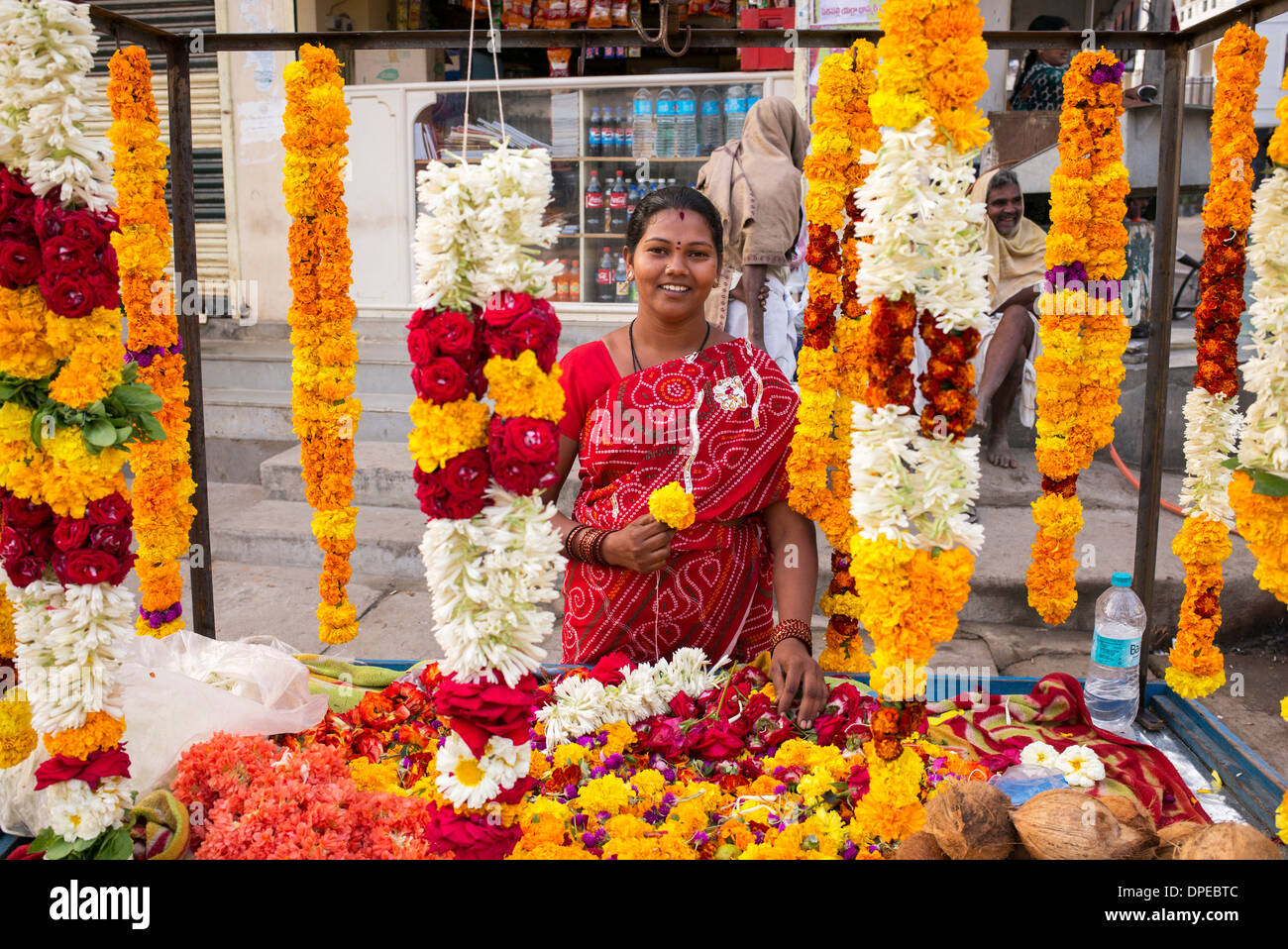 Indian woman selling flowers and garlands for hindu temple worship. Puttaparthi,   Andhra Pradesh, India Stock Photo