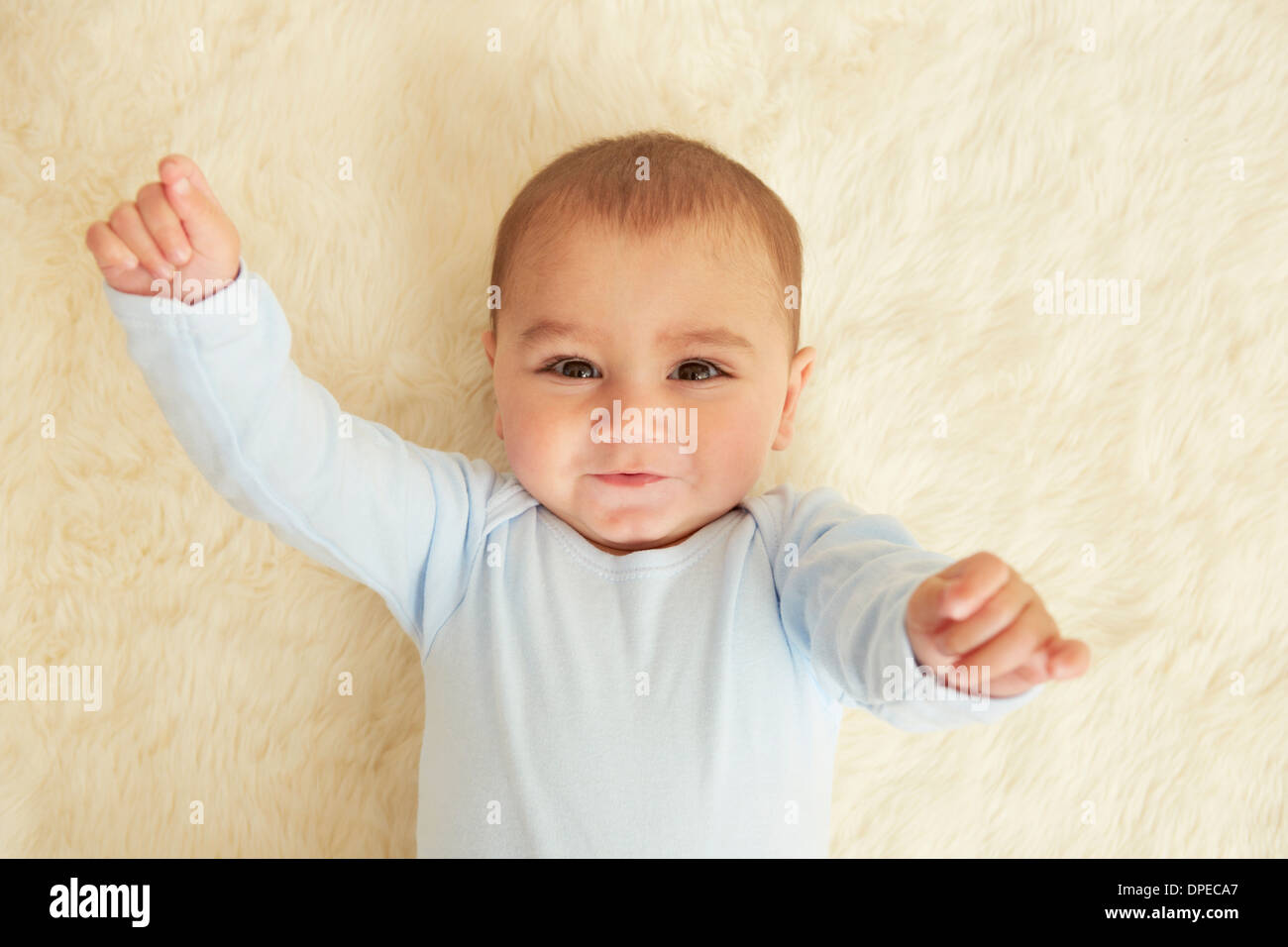 Baby lying on sheepskin rug Stock Photo Alamy