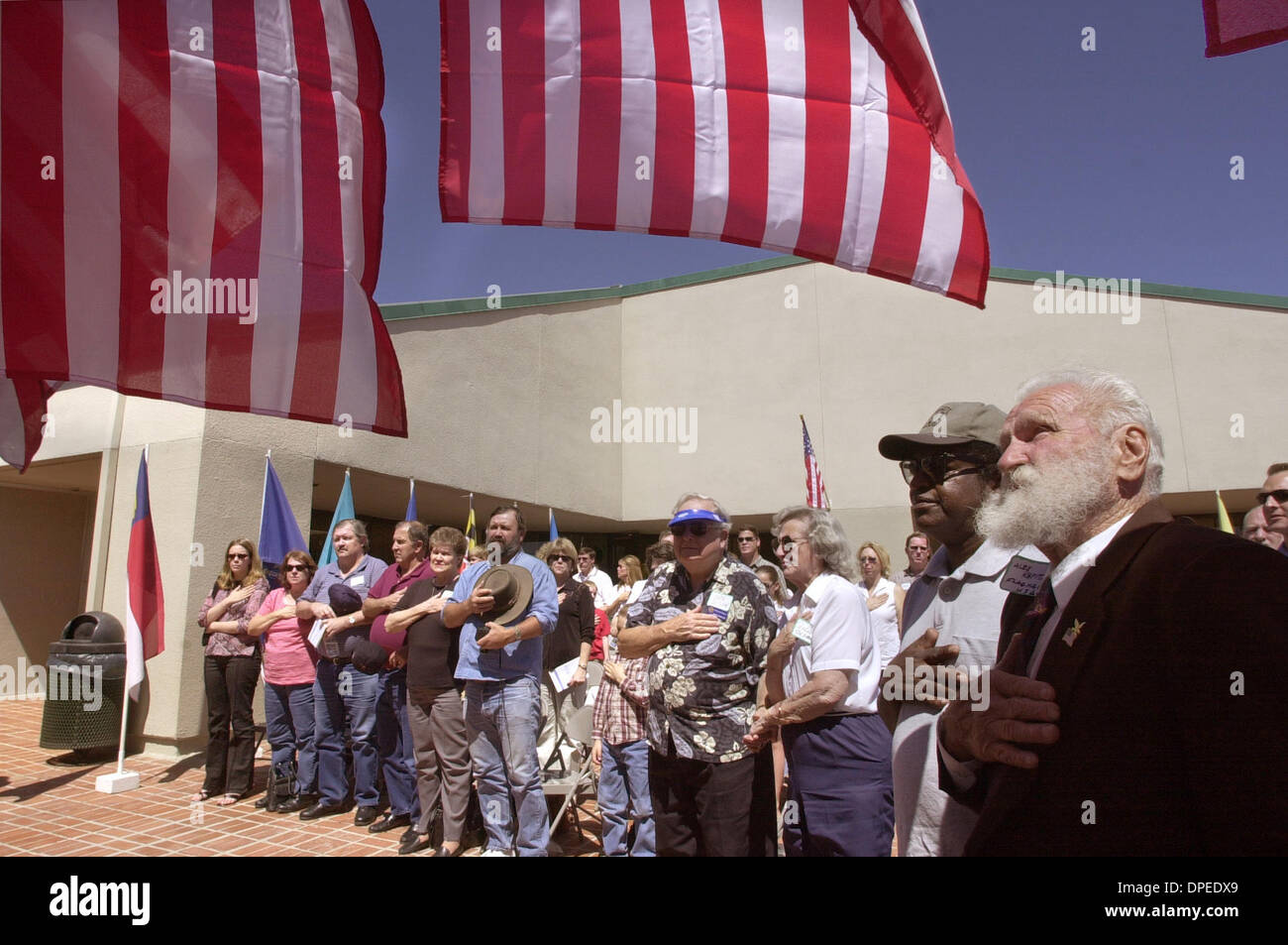(Published 03/30/2003, N-2:1) The audience recites the Pledge of Allegiance at the Melba Bishop Park and Recreation Center at the beginning of the dedication ceremony honoring Melba Bishop. At far right in beard is ALEX KAPITANSKI who supplied the flags for the event.  U/T photo CHARLIE NEUMAN Stock Photo