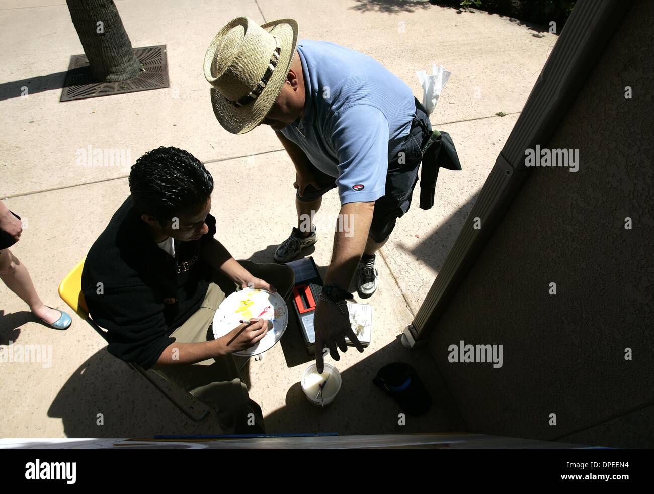 (PUBLISHED 04/16/2005, B-1:6 ) Howard Woodward (right) gives Jaime Rayon, 16, some pointers on his painting in front of the Mystic Art Studio in Imperial Beach.  Rayon attends Castle Park High School.  Earnie Grafton/UT Stock Photo