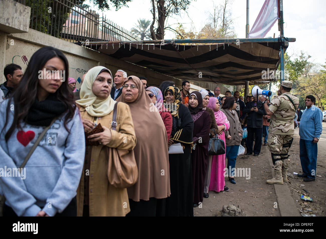 Cairo, Egypt. 14th Jan, 2014. People wait for entering a balloting station in Maadi district, Cairo, capital of Egypt, on Jan.14, 2014. Egyptians started casting their votes on Tuesday on the country's new draft constitution, which is widely seen as a milestone during Egypt's political transition after Islamist president Mohamed Morsi was ousted last July. Credit:  Pan Chaoyue/Xinhua/Alamy Live News Stock Photo