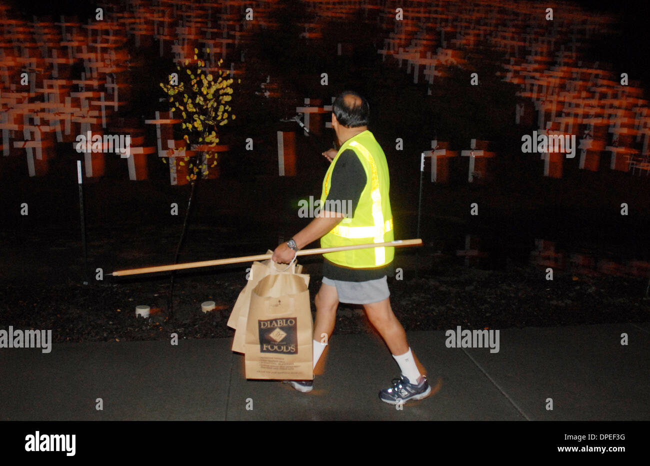 Trash collector John Quezada walks past the crosses picking up garbage