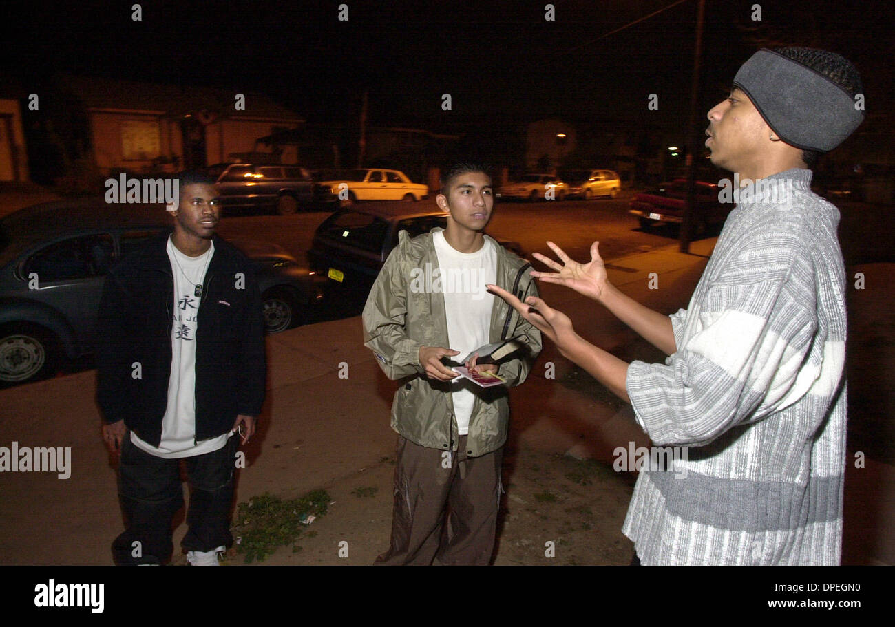 (PUBLISHED 01/12/2003, A-16): BOBBY BOGARD, 19, at far right, talks with Victory Outreach Church members P.J. WILLIAMS, far left, and ULYSSES GARCIA who were there in the Lincoln Park neighborhood meeting with the young people there.  U/T photo CHARLIE NEUMAN Stock Photo