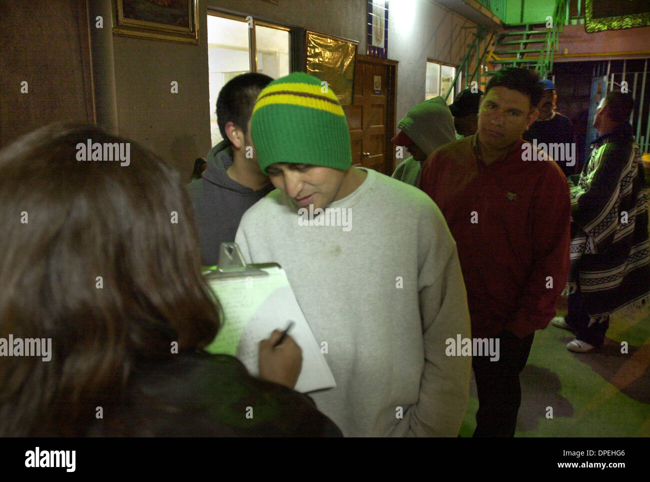 (published 01/23/2004, A-19; UTS1784910) After dinner at Tijuana's Casa De MIgrantes JOSE HUMBERTO PEREZ gets signed up for possible day work available around Tijuana tomorrow by Casa De Migrantes official MATILDE URUTIA.  U/T photo CHARLIE NEUMAN Stock Photo