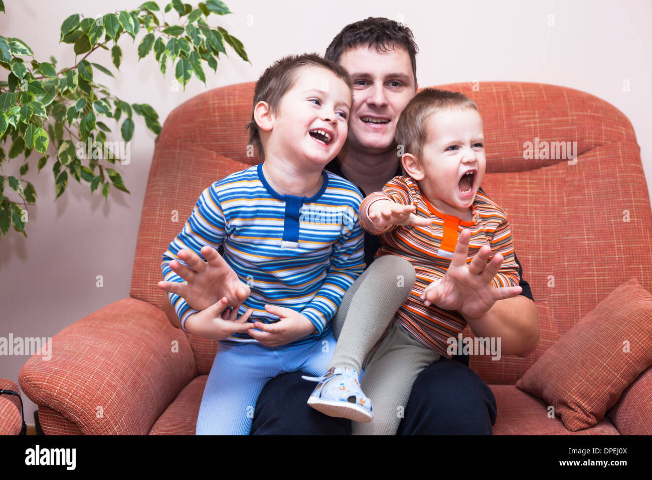 Happy children boys and daddy having fun on sofa at home Stock Photo