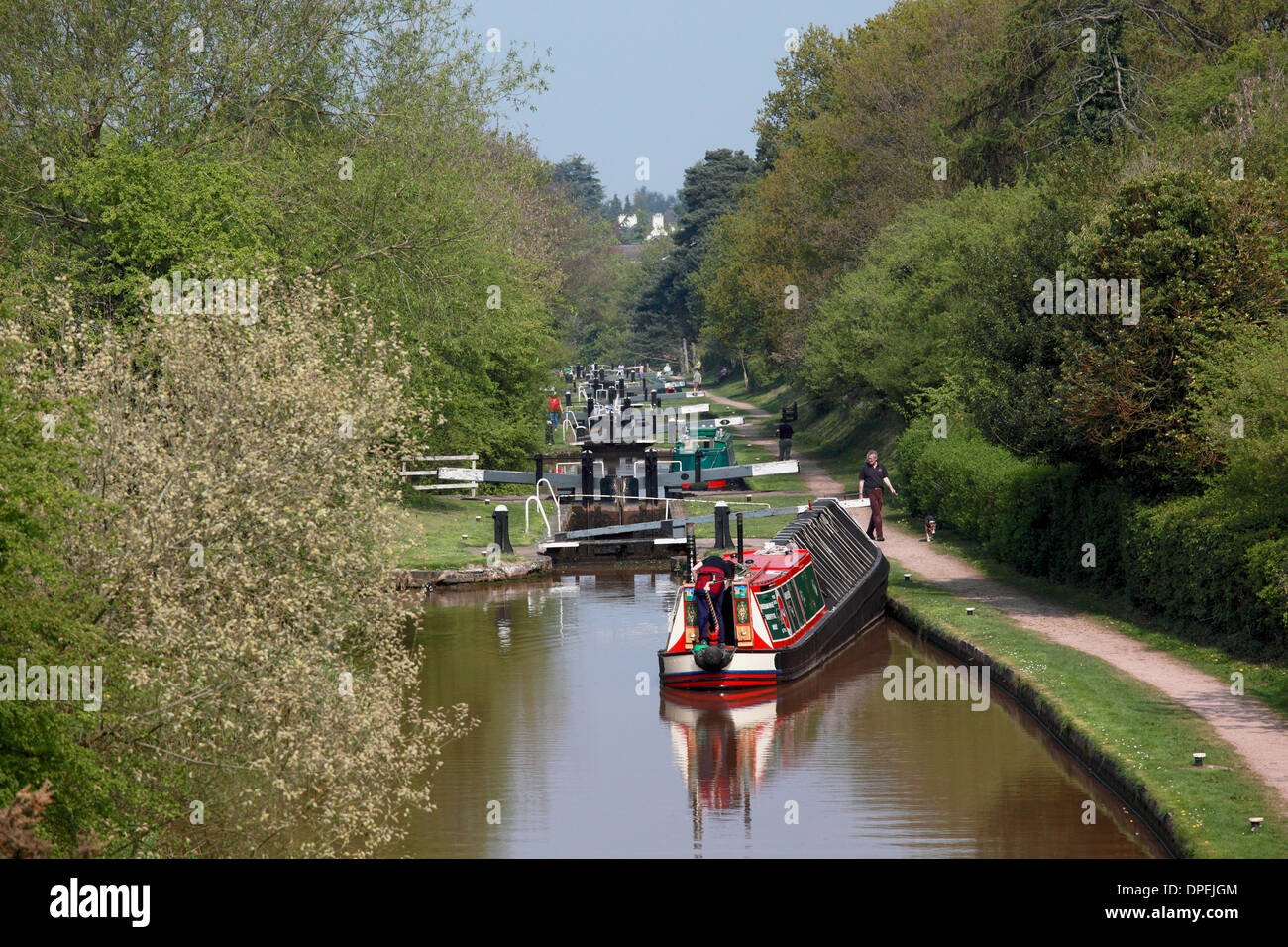 A traditional working narrowboat approaching Lock 8 of the Audlem flight of locks on the Shropshire Union Canal Stock Photo