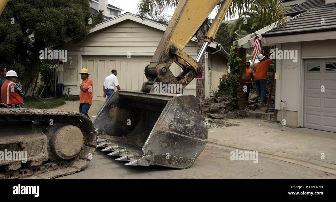 (PUBLISHED 03/18/3005, B-6:2,6,7; NC-2; NI-2) Work crews at right remove the entry way to a home threatened by a slide on Agua Dulce Court in La Costa on Thursday. Crews are widening the front entrance so the excavator at left can enter the back yard of the property and begin digging out the slide area. UT photob y Eduardo Contreras Stock Photo