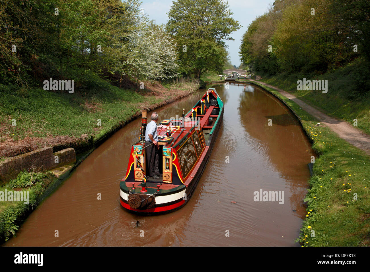 A traditional working narrowboat approaching Lock 6 of the Audlem flight of locks on the Shropshire Union Canal Stock Photo