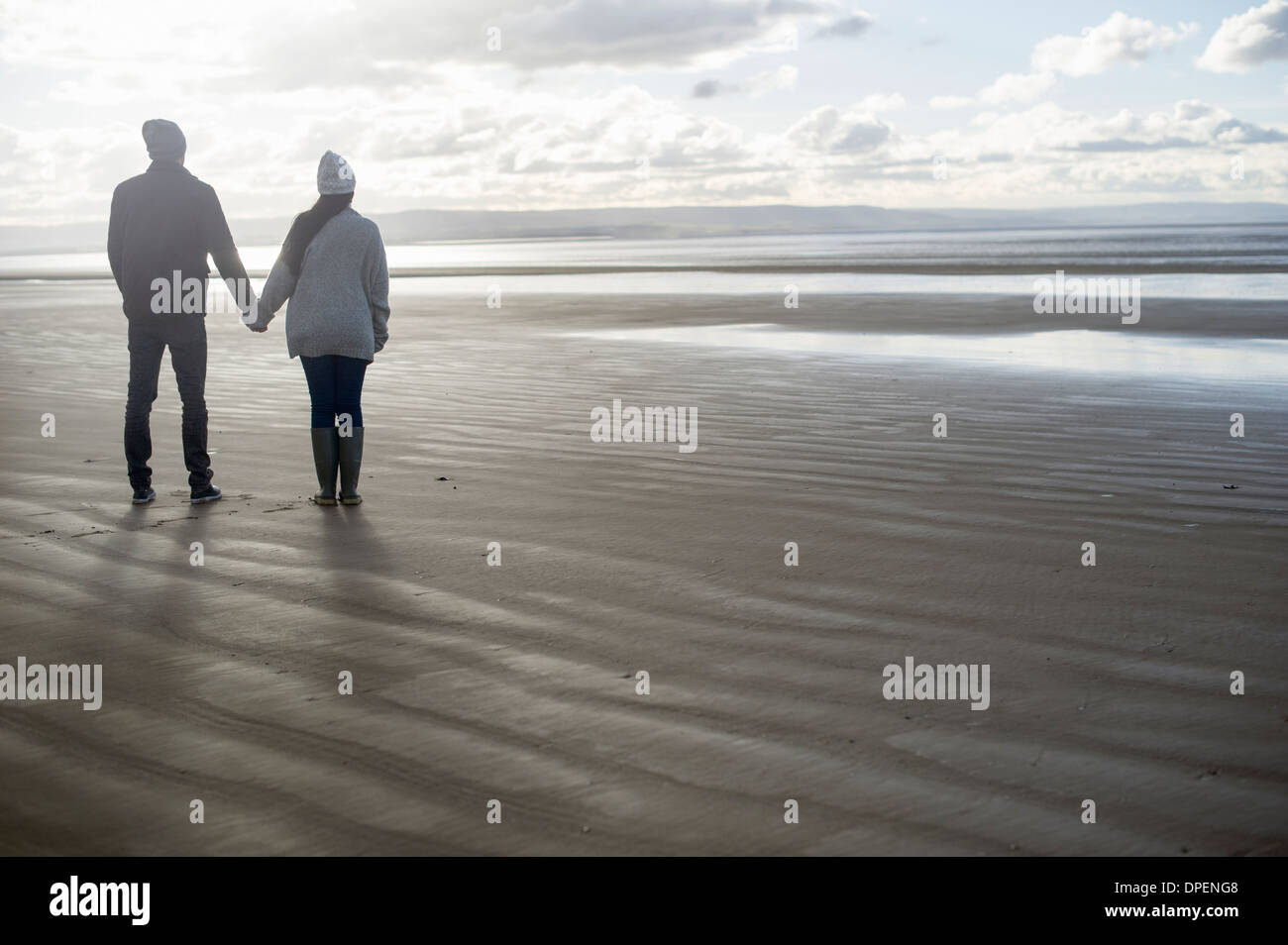Young couple holding hands, Brean Sands, Somerset, England Stock Photo