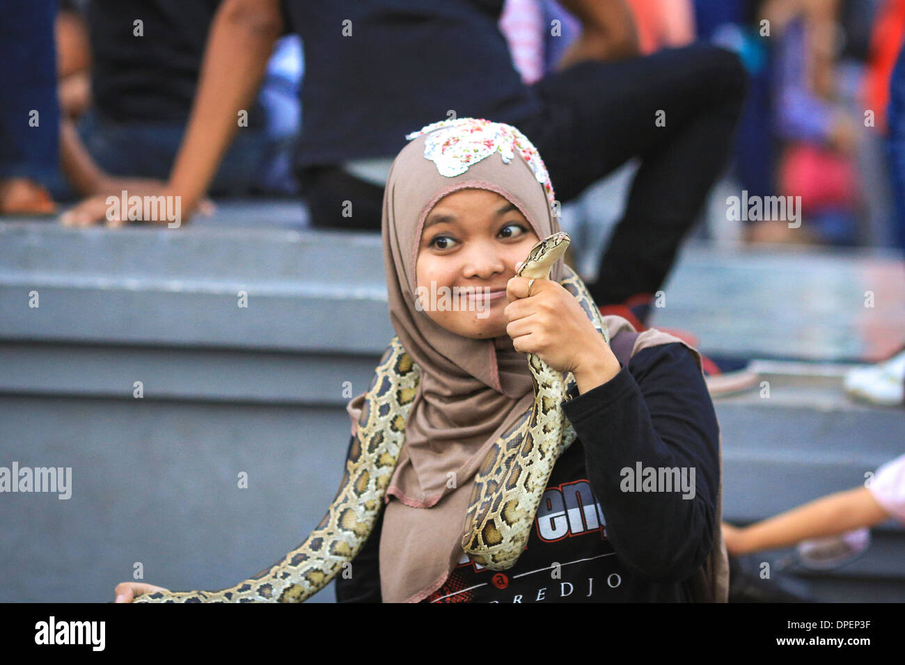 Indonesian woman holding a snake in Jakarta Kota, Indonesia Stock Photo