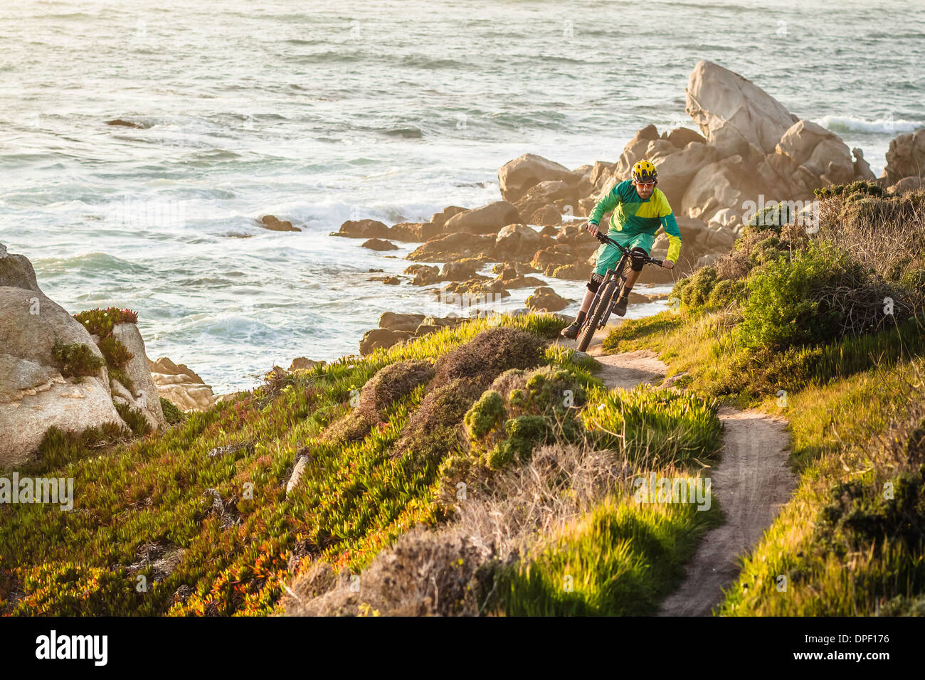 Mountain biker riding up coastal path, Monterey Bay area, California, USA Stock Photo