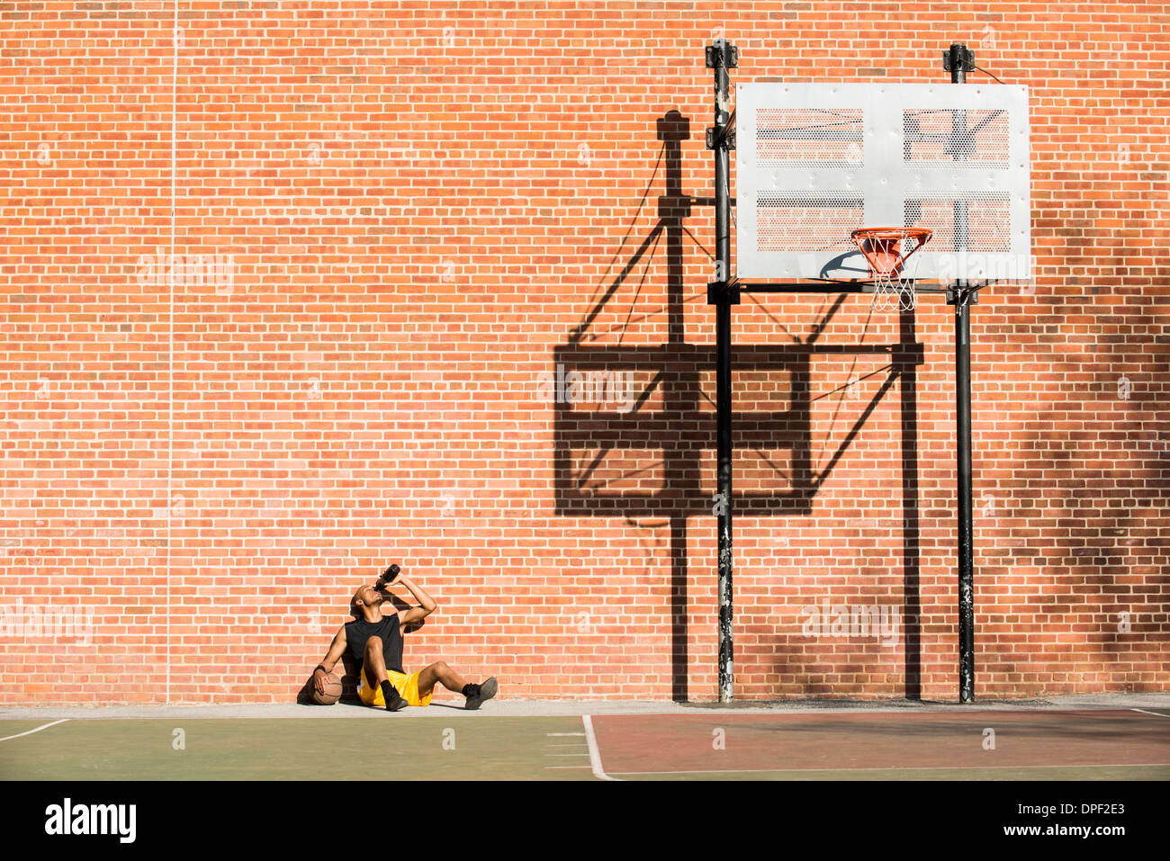 Basketball player resting on court Stock Photo
