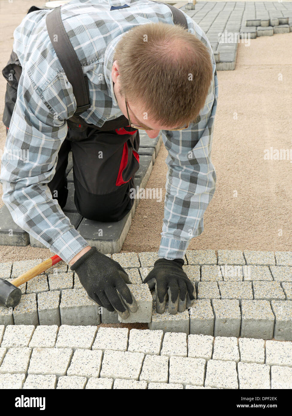 Paver laying pathway out of concrete pavement blocks Stock Photo