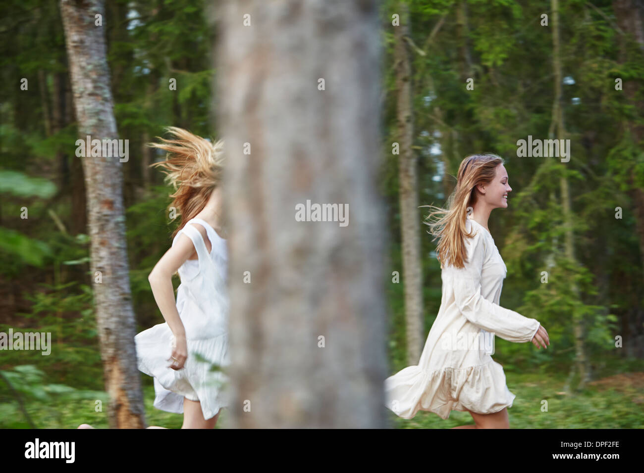Teenage girls running in forest Stock Photo