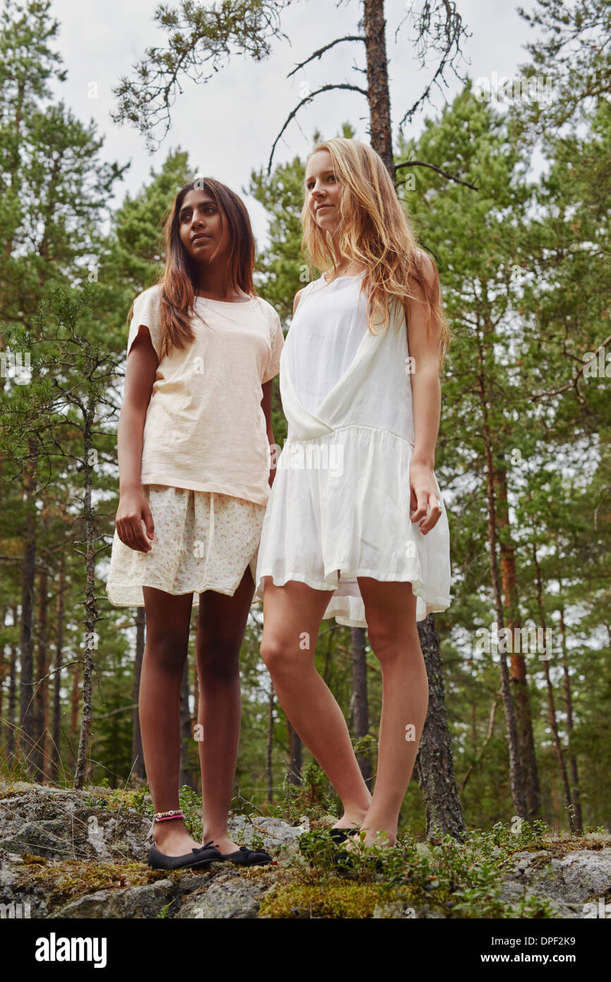 Portrait of teenage girls standing on rocks in forest Stock Photo