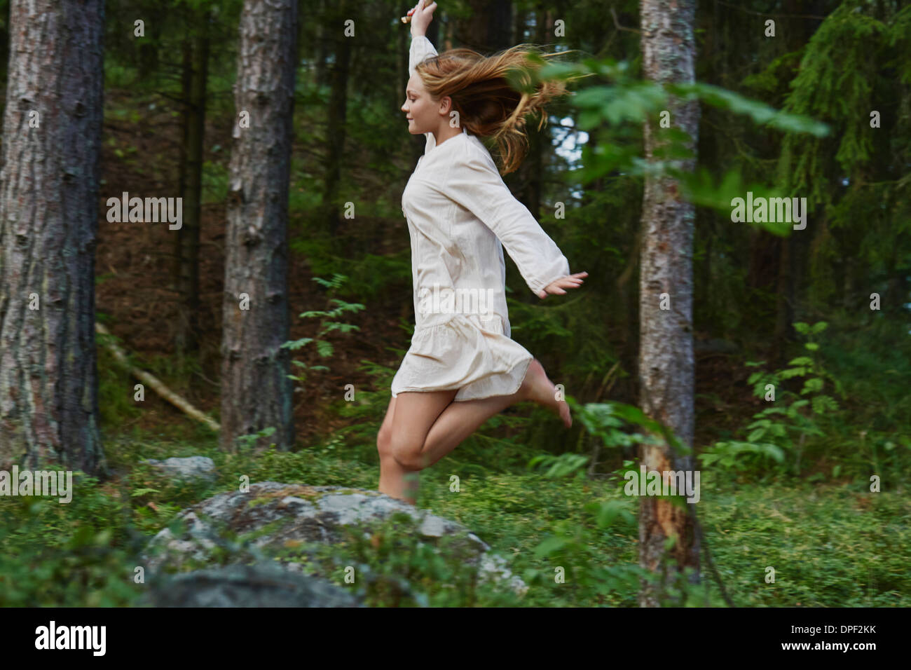Teenage girl running in forest Stock Photo