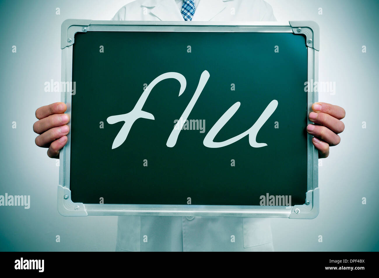 a doctor in white coat showing a chalkboard with the word flu written in it Stock Photo