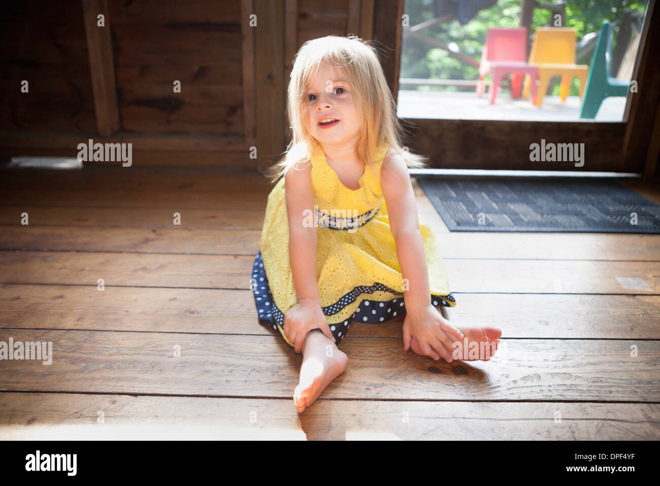 Female toddler sitting on wooden floor Stock Photo - Alamy