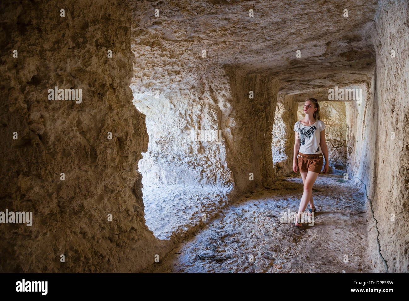 Tourist exploring the tunnels at the Greek ruins, Eurialo Casle (Castello Eurialo), Syracuse (Siracusa), Sicily, Italy, Europe Stock Photo