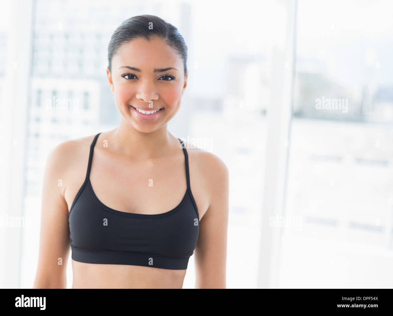 Cheerful dark haired model in sportswear posing looking at camera Stock Photo