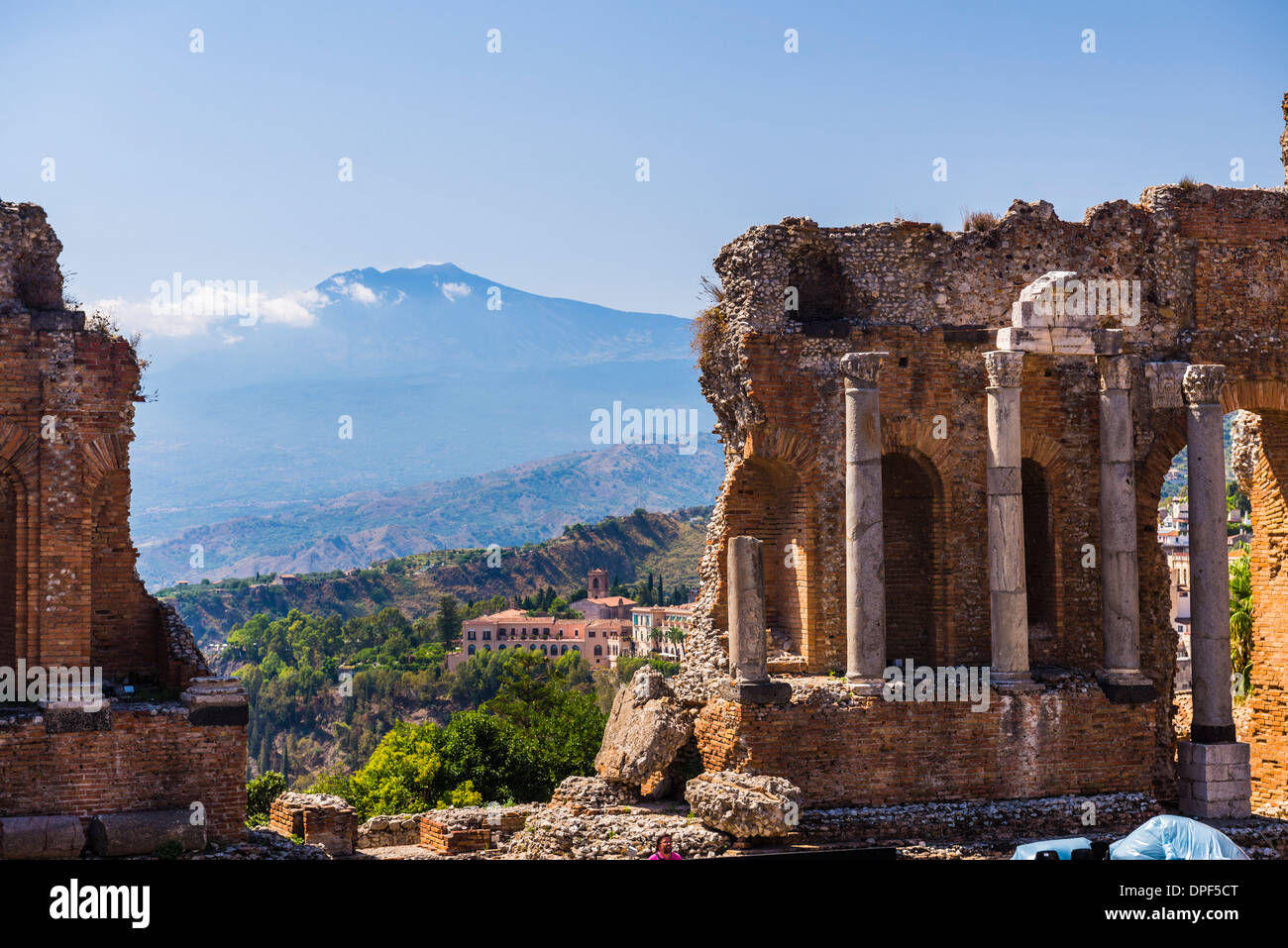 Teatro Greco (Greek Theatre), ruins of columns at the amphitheatre, and Mount Etna volcano, Taormina, Sicily, Italy, Europe Stock Photo