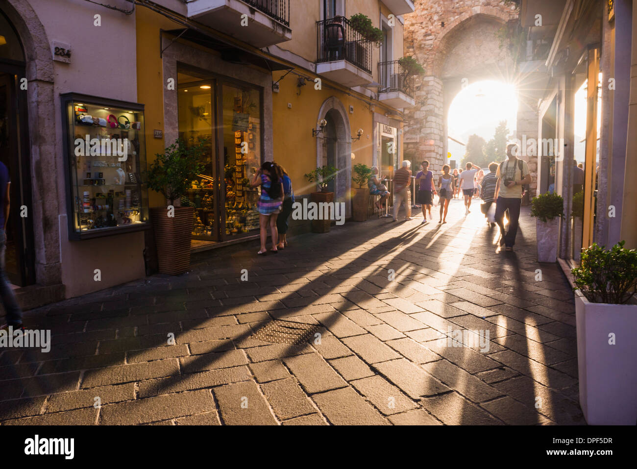 Tourists entering Corso Umberto, the main street in Taormina at sunset, Sicily, Italy, Europe Stock Photo