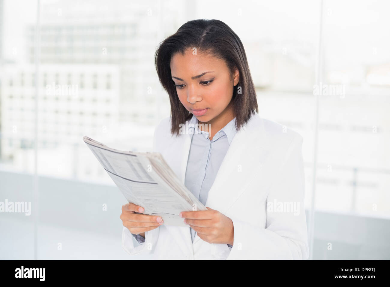 Focused young dark haired businesswoman reading a document Stock Photo
