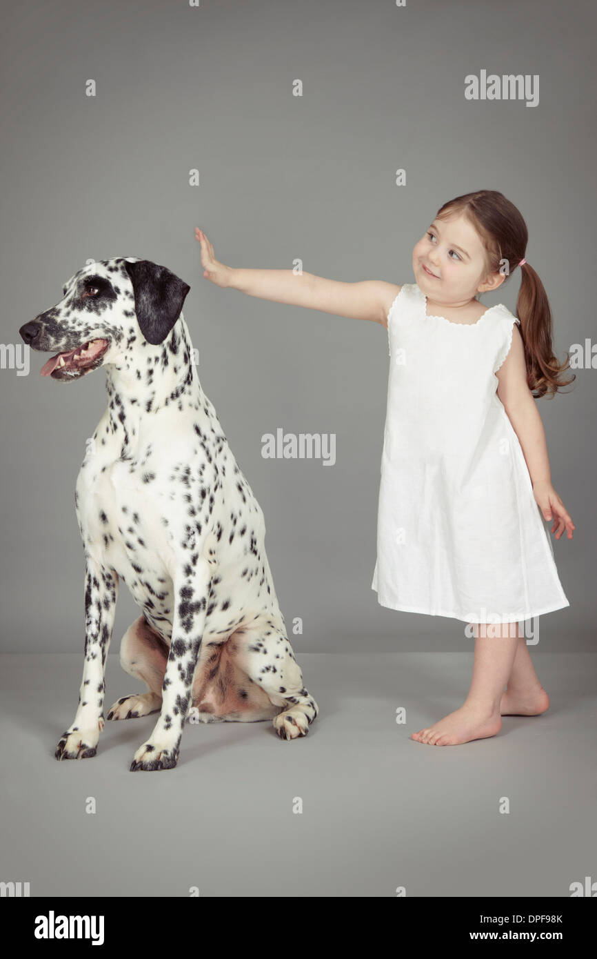 Studio portrait of female toddler and dalmatian dog Stock Photo