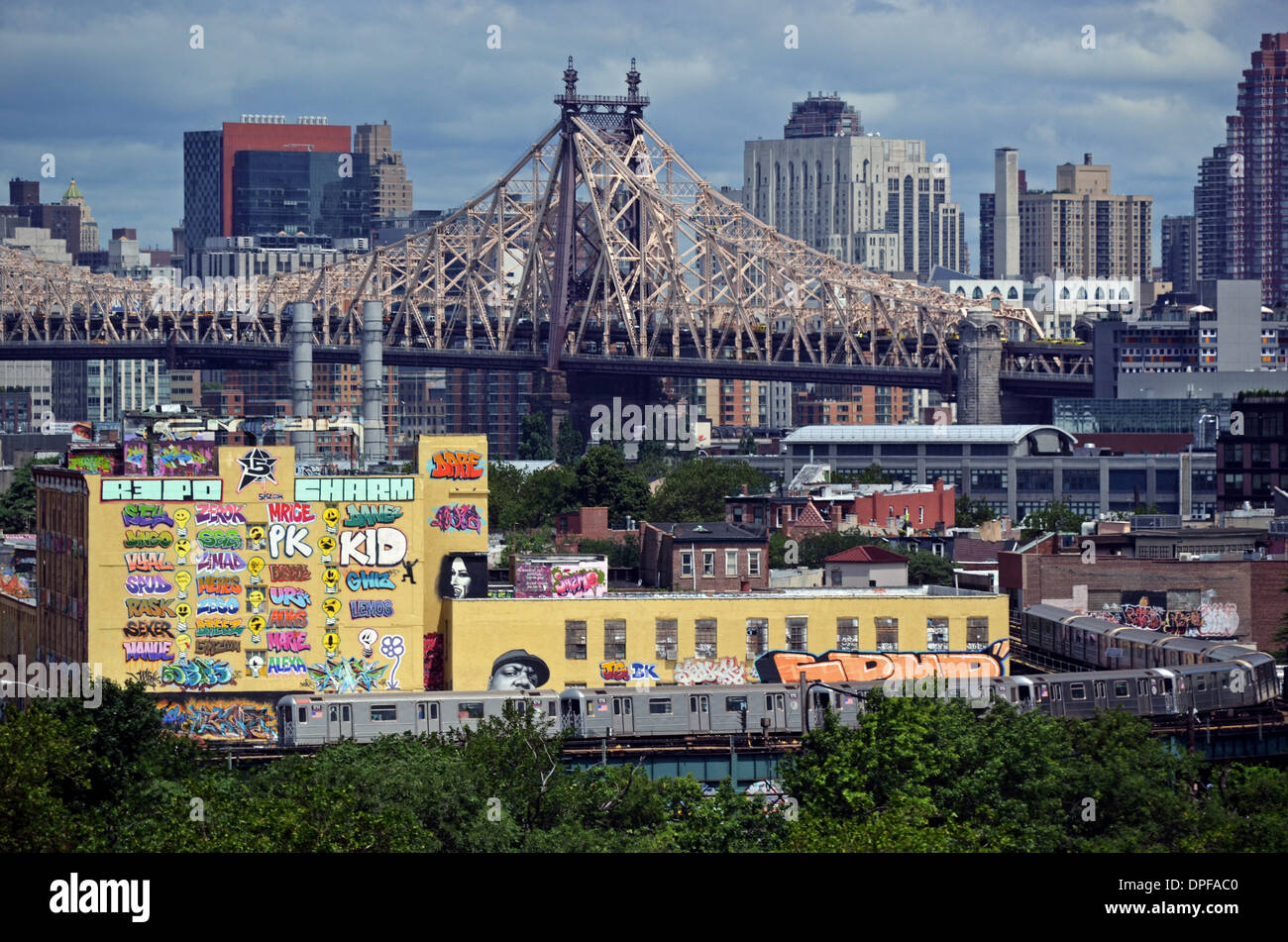 5 Pointz graffiti museum with the 59th Street Bridge and Manhattan skyline in the background and the subway in the foreground. Stock Photo