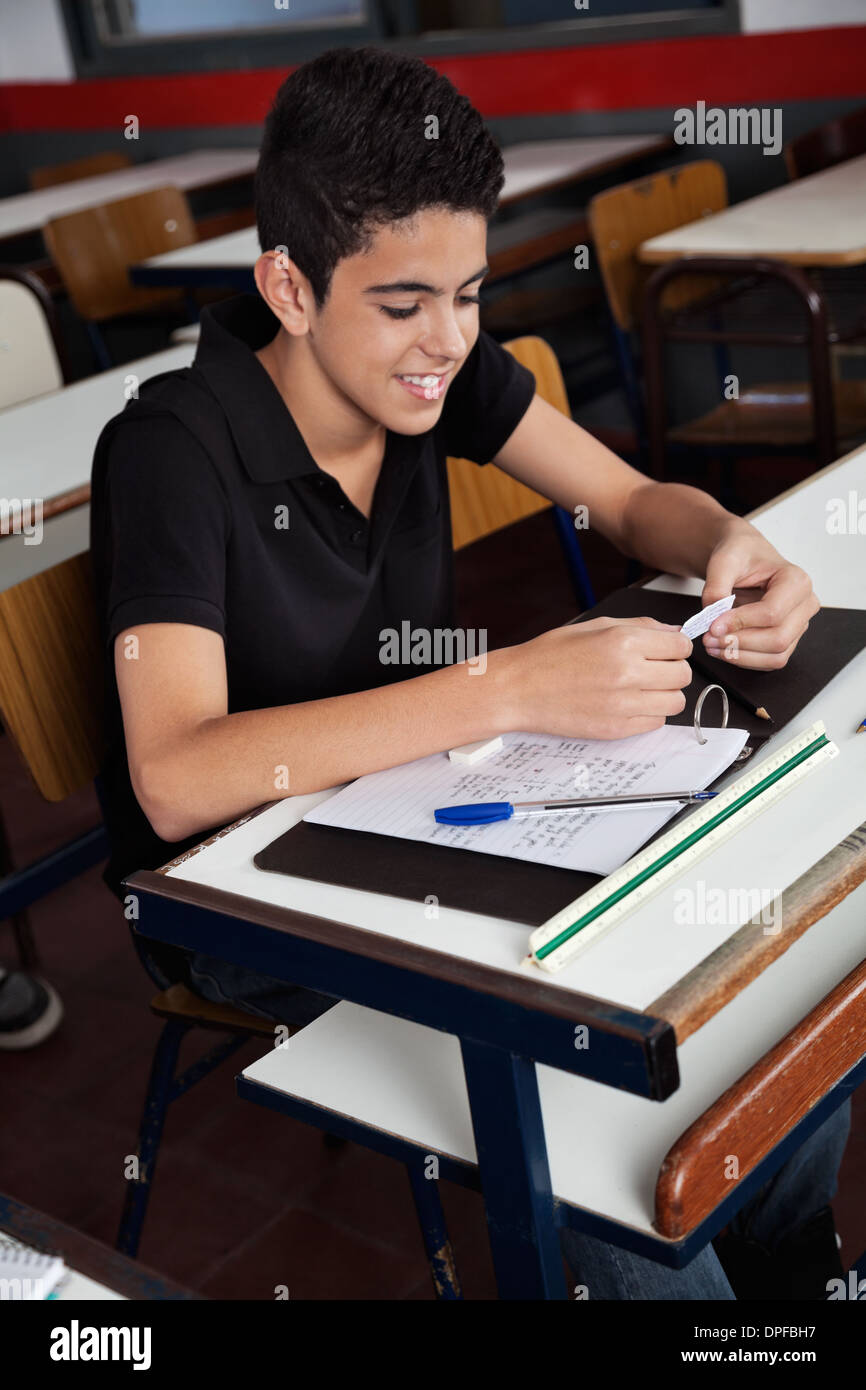Schoolboy Copying From Cheat Sheet At Desk Stock Photo